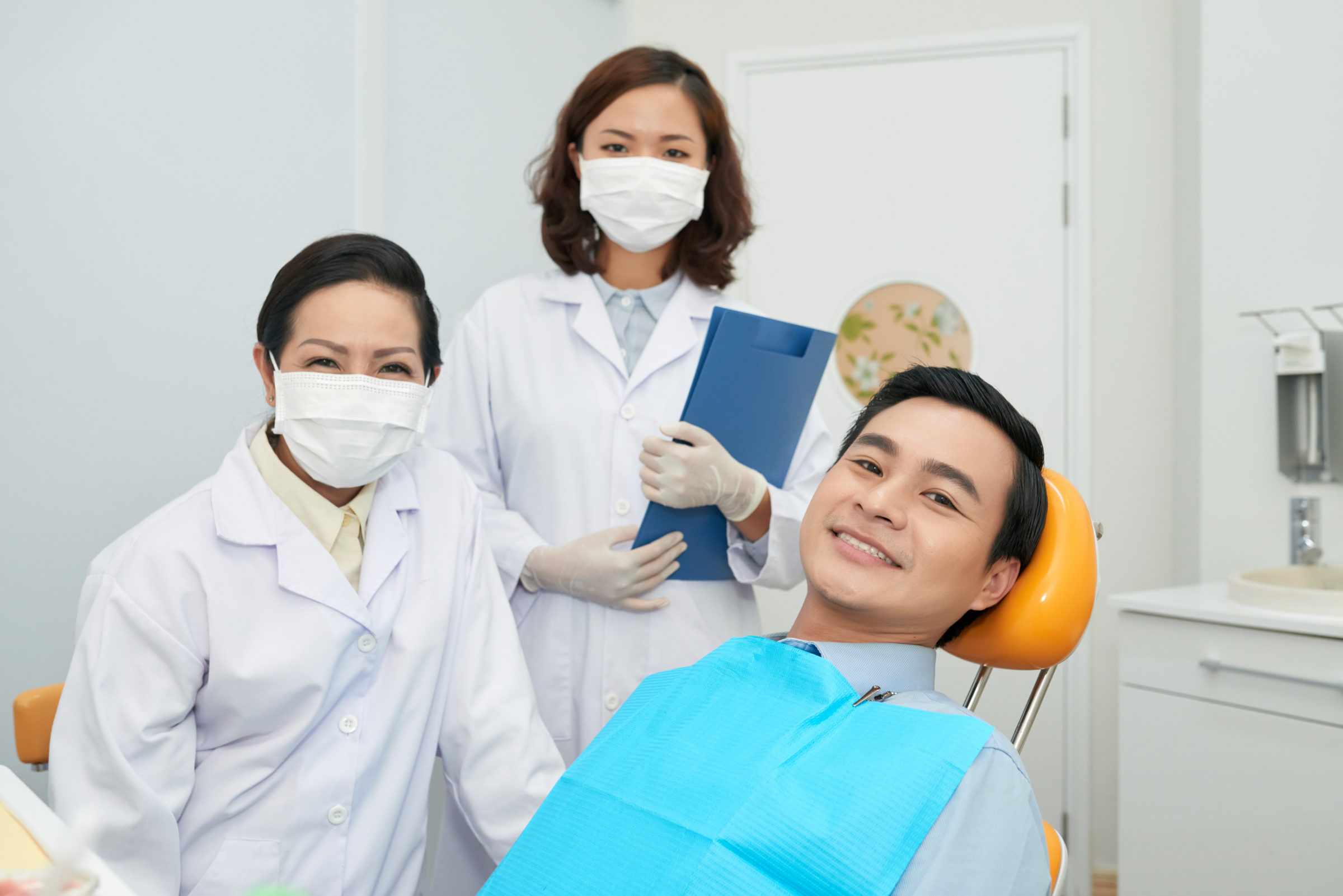 smiling-patient-and-doctors-in-dental-office-6XP9ZNT.jpg